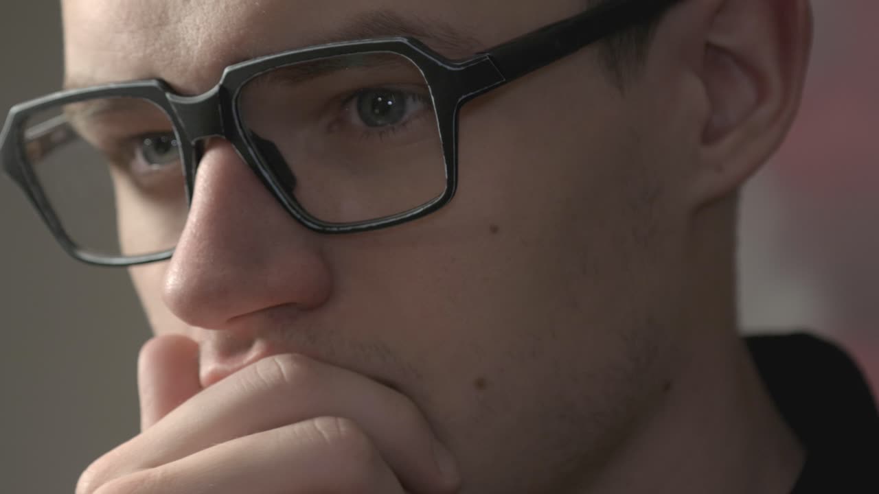 Attractive Man In Glasses With Blue Eyes Rubbing His Chin And Thinking.- closeup shot