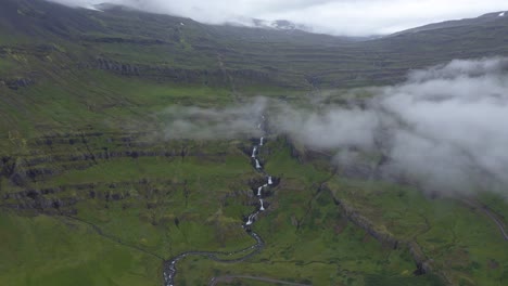 toma aérea de hermosas cascadas de siete niveles en islandia durante un día nublado rodeado de montañas con vegetación