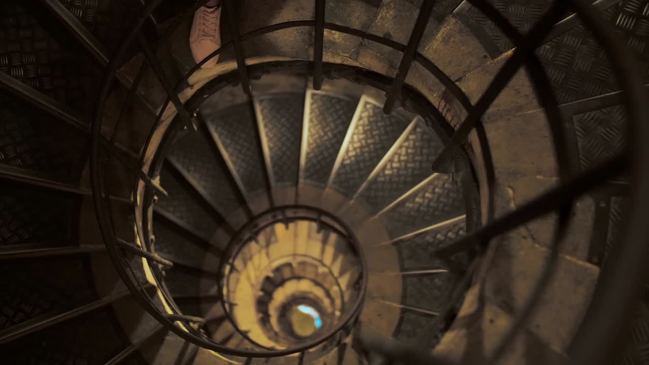 Panoramic shot of a high spiral staircase from above. Focus on the front of the stairs. The concept of an unknown future