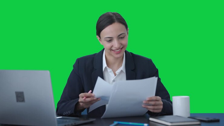 mujer de negocios india feliz chequeando informes pantalla verde