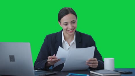 mujer de negocios india feliz chequeando informes pantalla verde