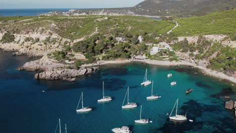 drone shot of yachts and sailboats on es canaret beach in ibiza, spain