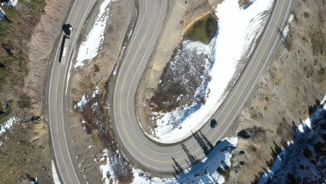 vista aérea de la carretera en zigzag en la autopista de un millón de dólares en colorado con un camión y un video de drones semirremolques