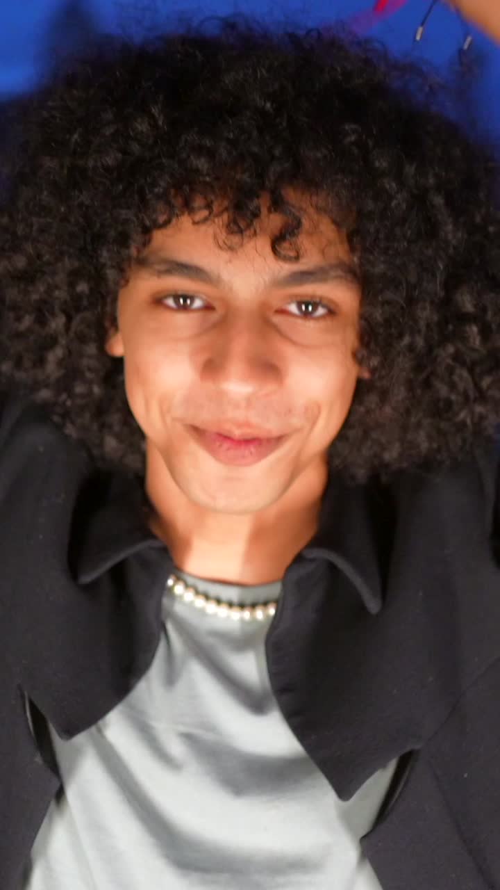 Portraits of a young man with curly hair and a pearl necklace