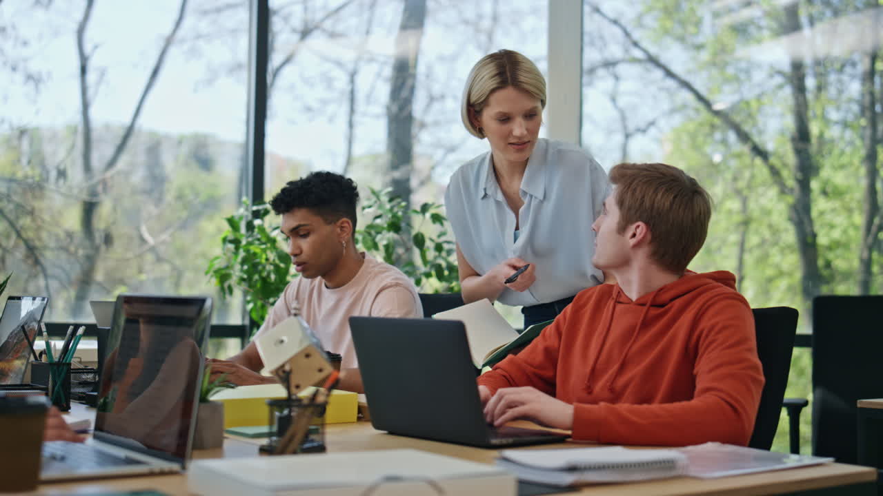 Woman expert helping interns work place. Corporate mentor training young worker