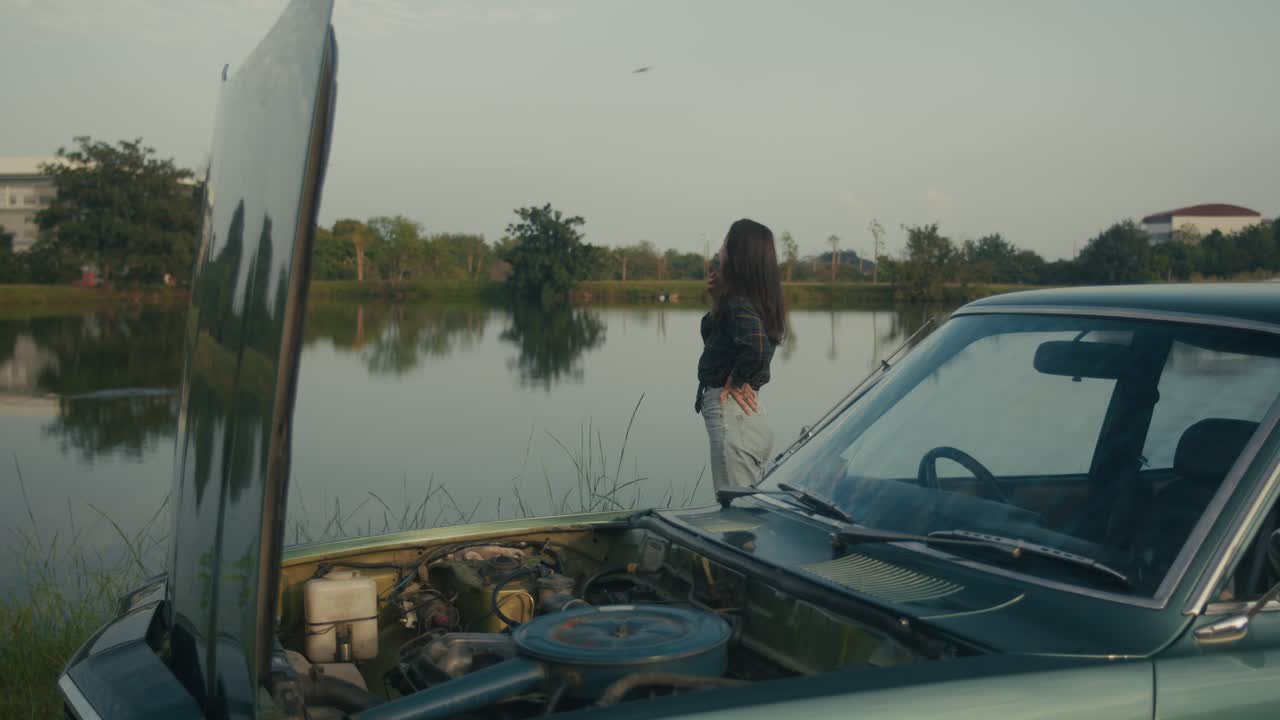 Woman by a Broken Down Vintage Car by a Lake