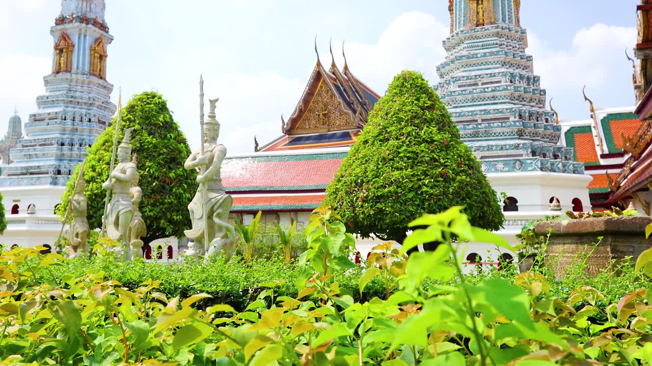 Lush greenery and ornate architecture at Wat Phra Kaew in Bangkok, captured under bright daylight with a steady camera