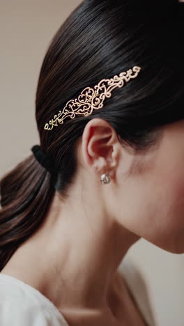 close-up of a woman's hair with an ornate golden hair clip and earring