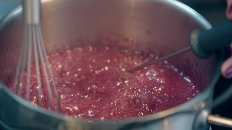 confectioner mixes boiling caramel using thermometer