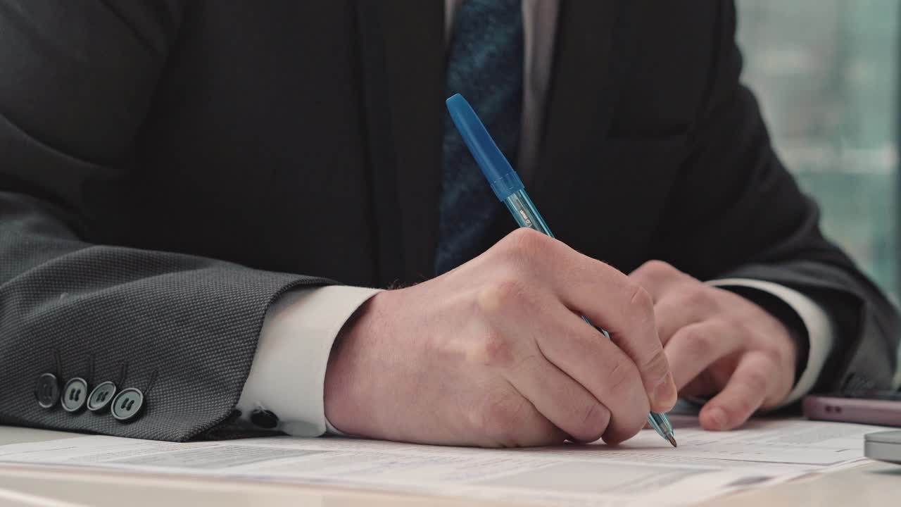 Businessman taking notes or signing contract, pen and document, man in formal jacket. Close up hand