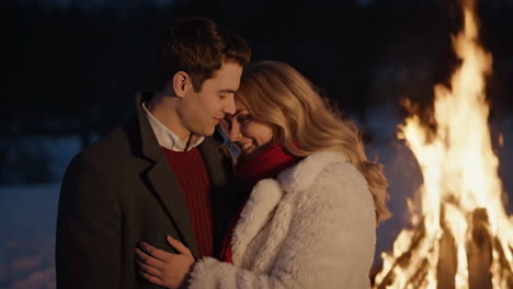 couple embracing by a bonfire in winter