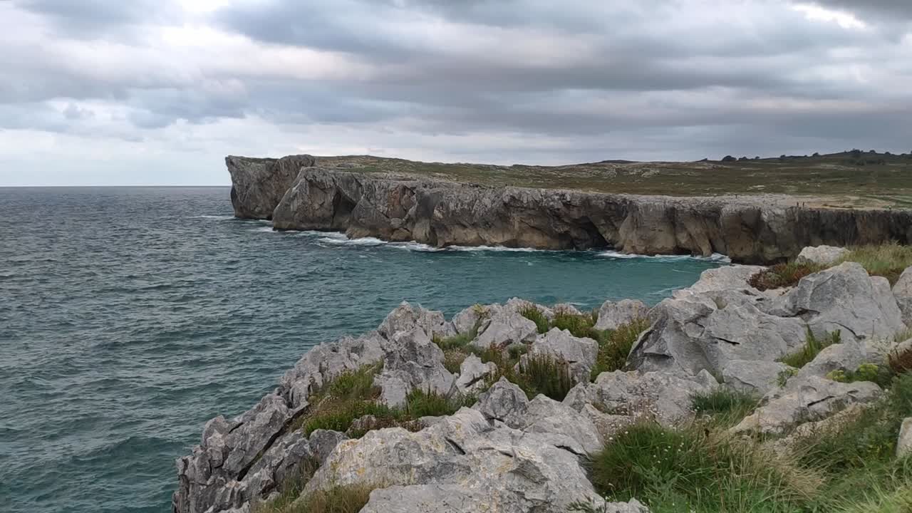 Rugged coastline and ocean waves hitting the Guadamia cliffs in Asturias, Spain