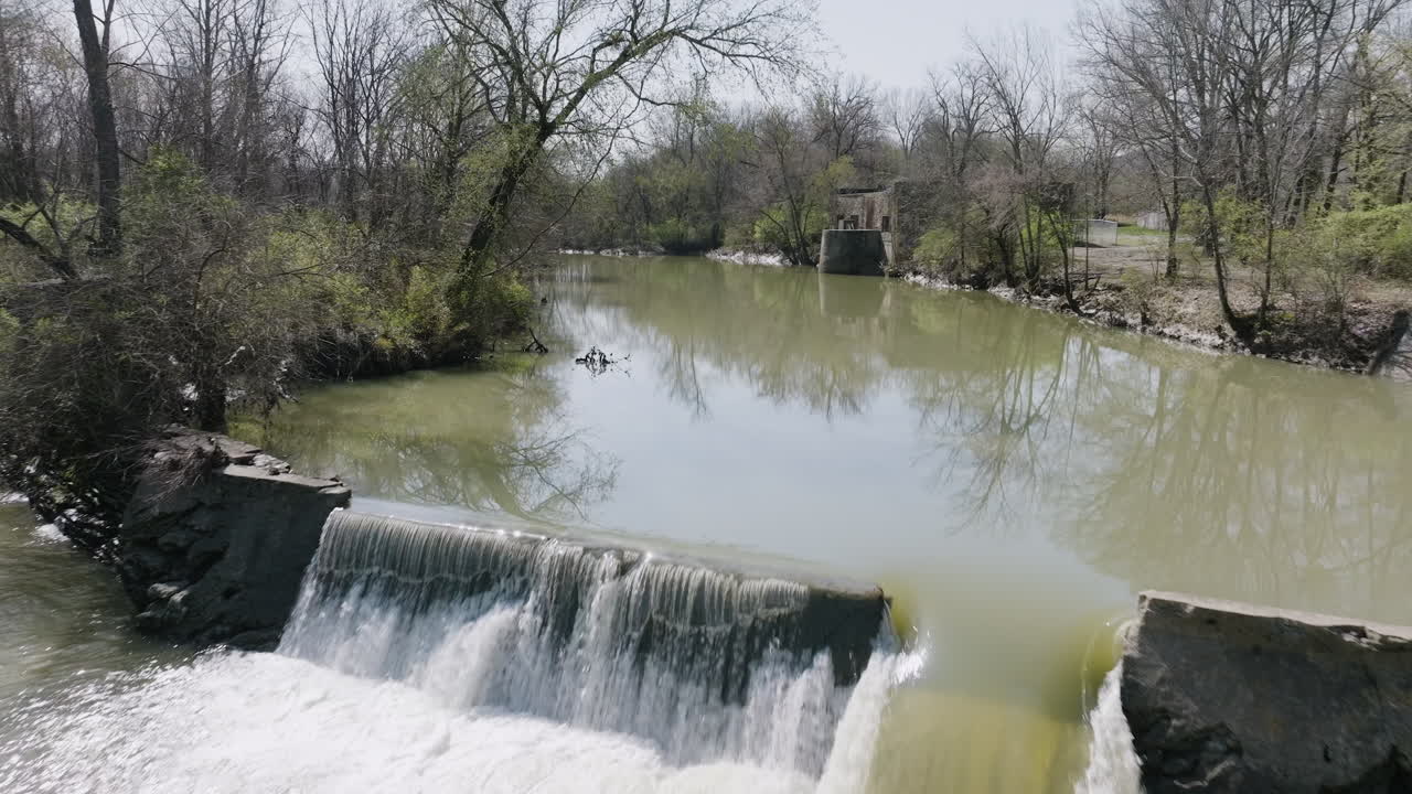 Slow motion dolly toward a small dam with an abandoned pump station at White River