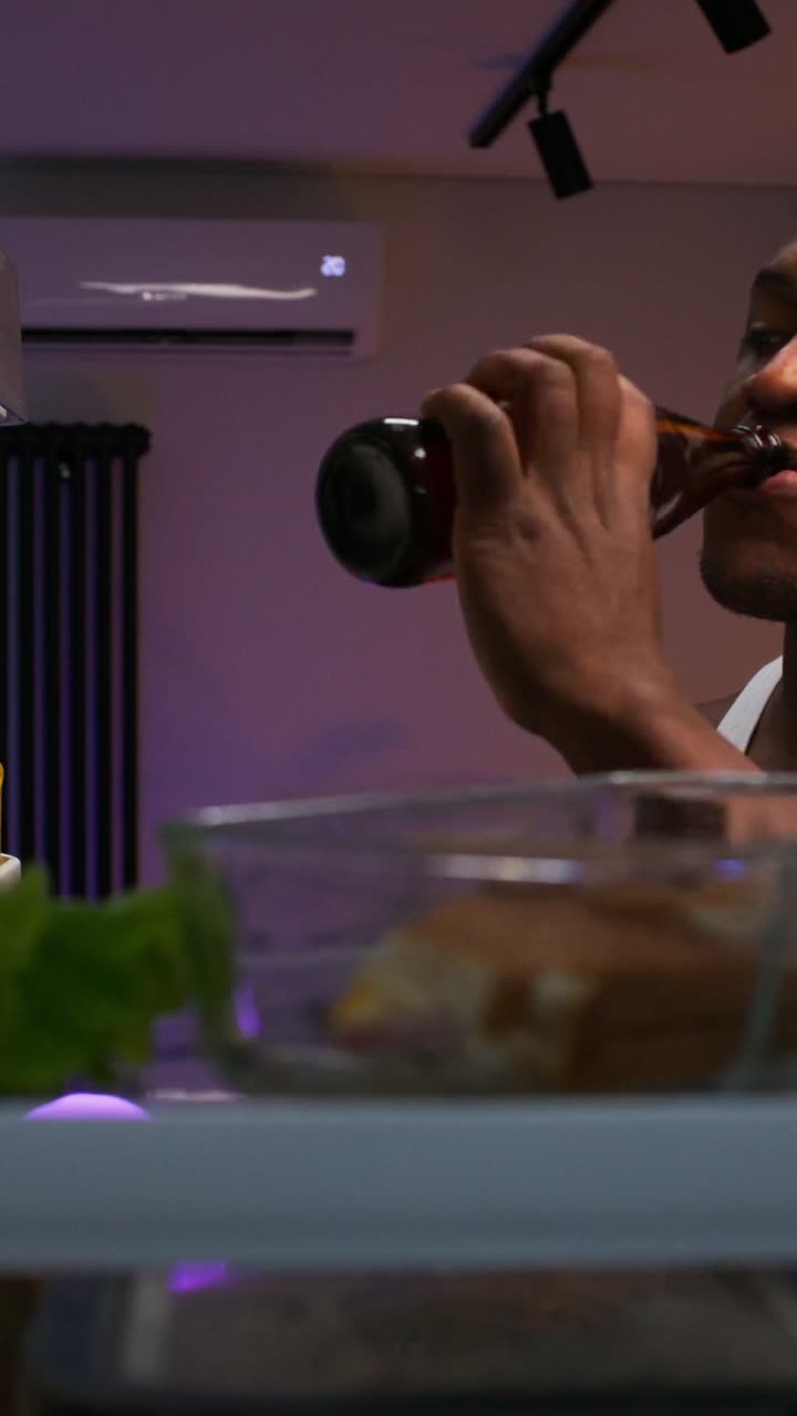 Man drinking beer near the refrigerator