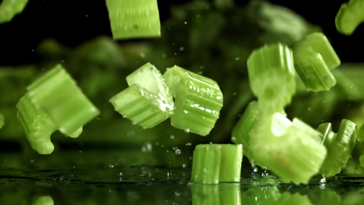 Chopped Celery Pieces Falling and Splashing Water in Slow Motion