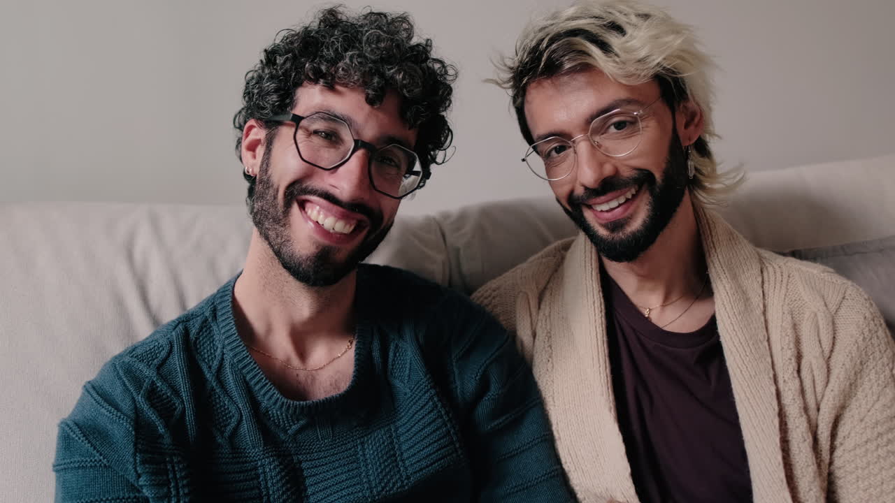 Happy Gay Couple Smiling Together on Sofa