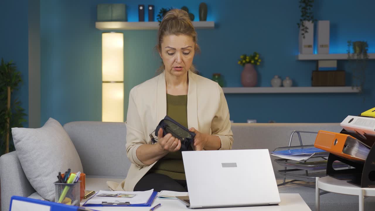 Home office worker woman showing her empty wallet to the camera.