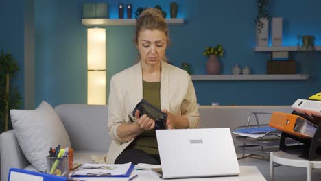 Home-office-worker-woman-showing-her-empty-wallet-to-the-camera.