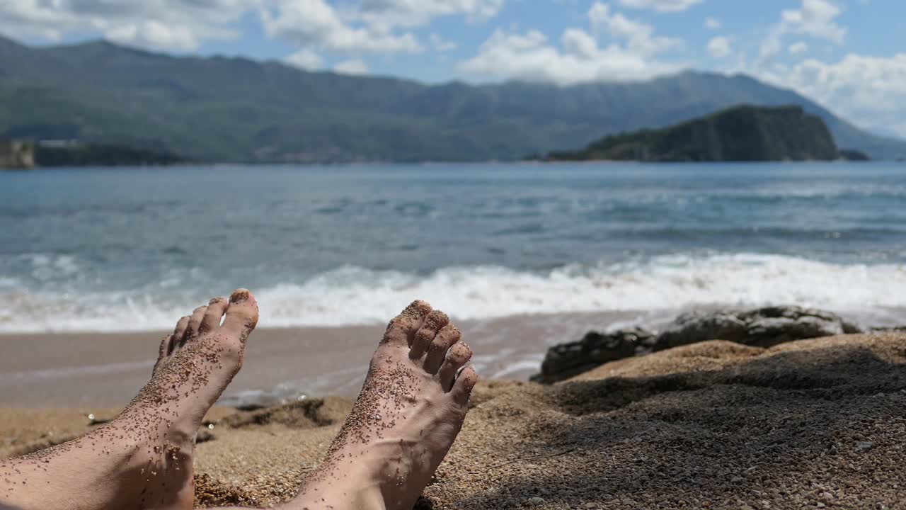hombre con pies de arena en una hermosa playa natural, mediterránea