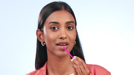 maquillaje, lápiz labial y mujer india guiña el ojo en el estudio