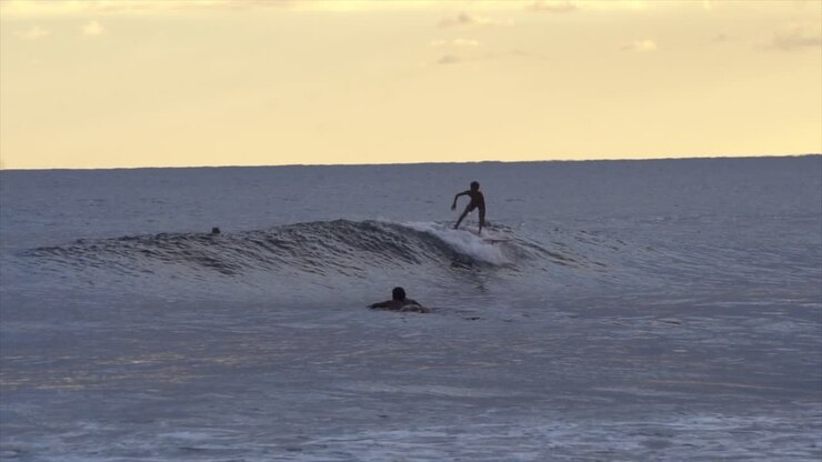 SLO MO Young Surfer Catching Waves in Burnt Orange Sunset, Indonesia