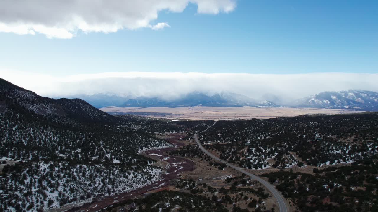 vista aérea de drones de una carretera remota con montañas rocosas en la distancia