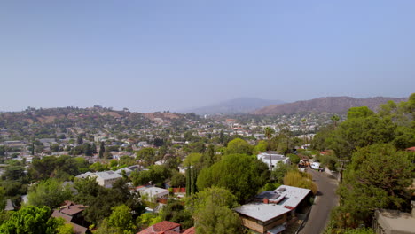 Low-altitude-flight-over-houses-and-street-in-Los-Angeles-neighborhood-of-Eagle-Rock,-California-on-a-beautiful-summer-day