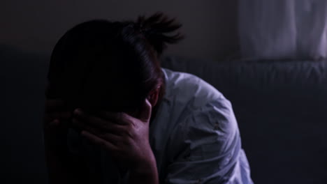 covering her face, a the woman is shedding tears out of her frustration and grief