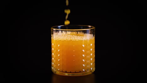 orange juice being poured into a glass