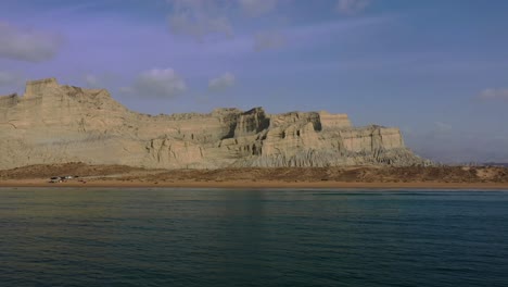 Aerial-Over-Arabian-Sea-With-Rugged-Mountains-Of-Hingol-National-Park-In-Background