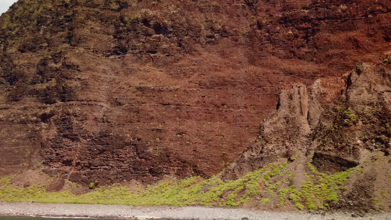 Gimbal close-up POV shot from a moving boat of the rugged shoreline and rocky cliffs along the southern edge of the Na Pali Coast on the island of Kaua'i, Hawai'i