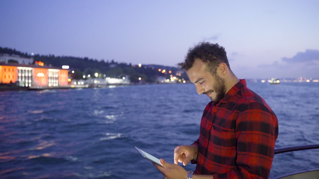 hombre usando tableta en moto acuática. feliz.
