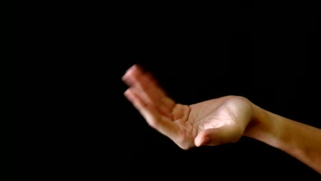 el gesto de la mano masculina sobre un fondo negro.