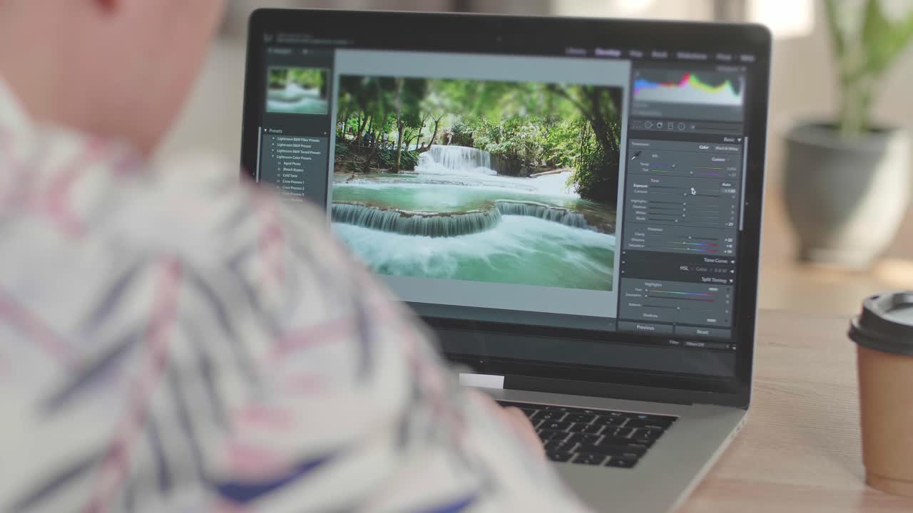 Man Works In Photo Editing App / Software On His Laptop Computer. Photo Editor Retouching Photos Of Beautiful Nature