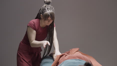mujer dando masaje al cliente