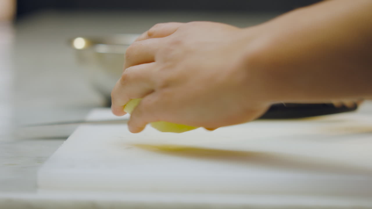 Close-up of a chef slicing an apple on a chopping board