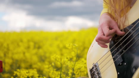 Primer-Plano-De-Una-Mujer-Tocando-Una-Guitarra-Saltando-Y-Bailando-Vigorosamente-Moviendo-La-Cabeza-Y-El-Cabello.-La-Cámara-En-Vivo-Se-Mueve-Junto-Con-El-Guitarrista-Con-Un-Traje-Amarillo.-Periodista-Incendiario-Divertido