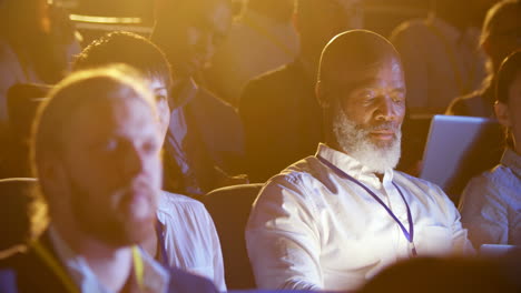 empresario afroamericano usando una computadora portátil durante un seminario en el auditorio 4k