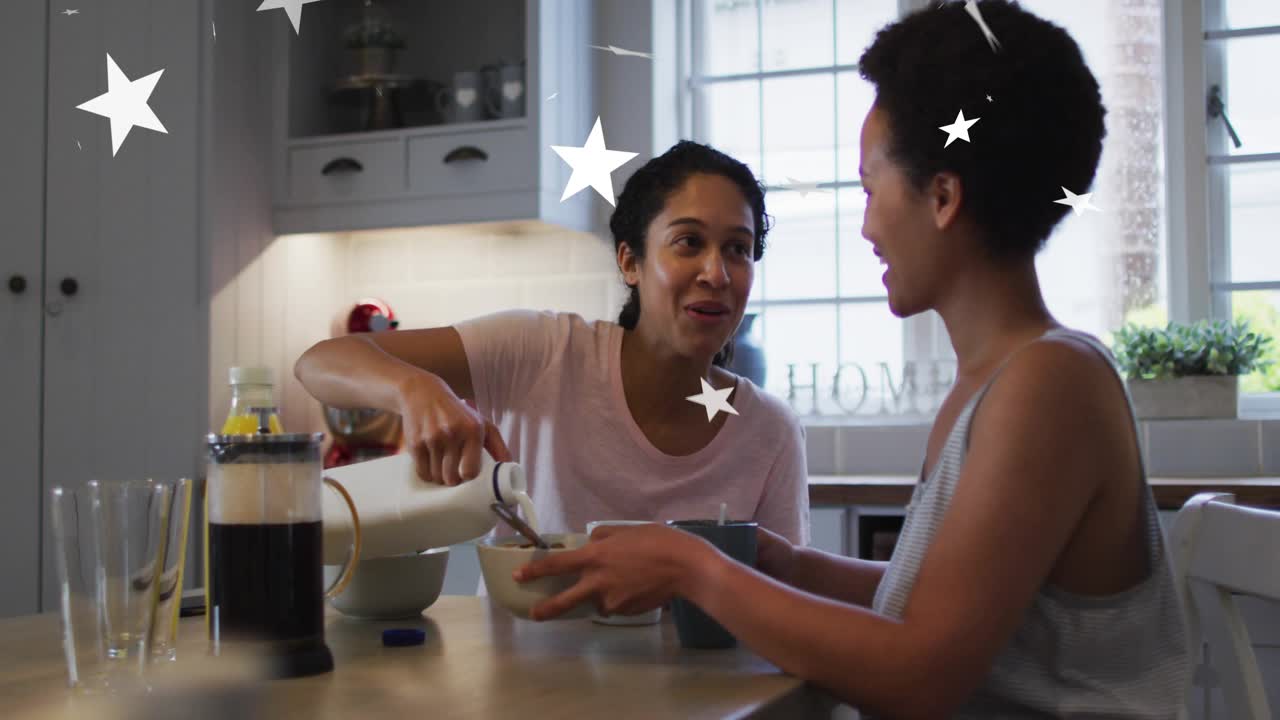Women scooping mixture from stand mixer at island, initiating floating stars for food marketing