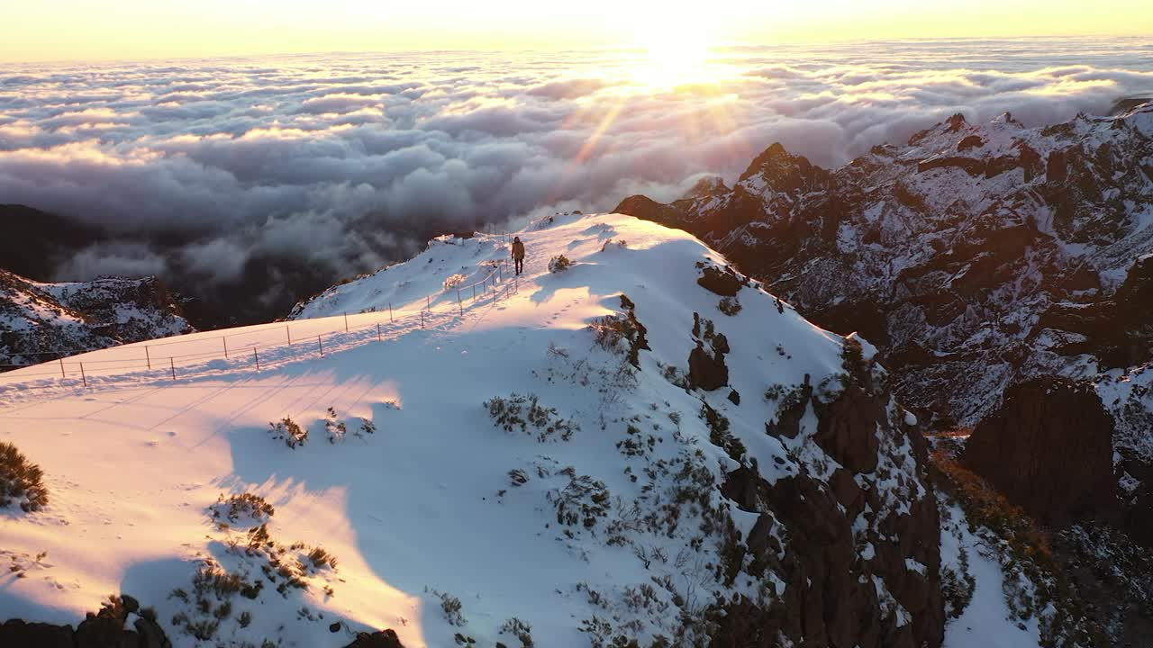 un hombre camina solo al atardecer en la cima de la montaña pico ruivo