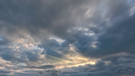 timelapse of sun rays emerging though the dark storm clouds in the mountains