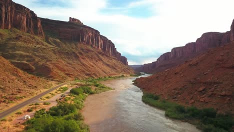 rising aerial drone shot over the colorado river as it snakes through a desert canyon