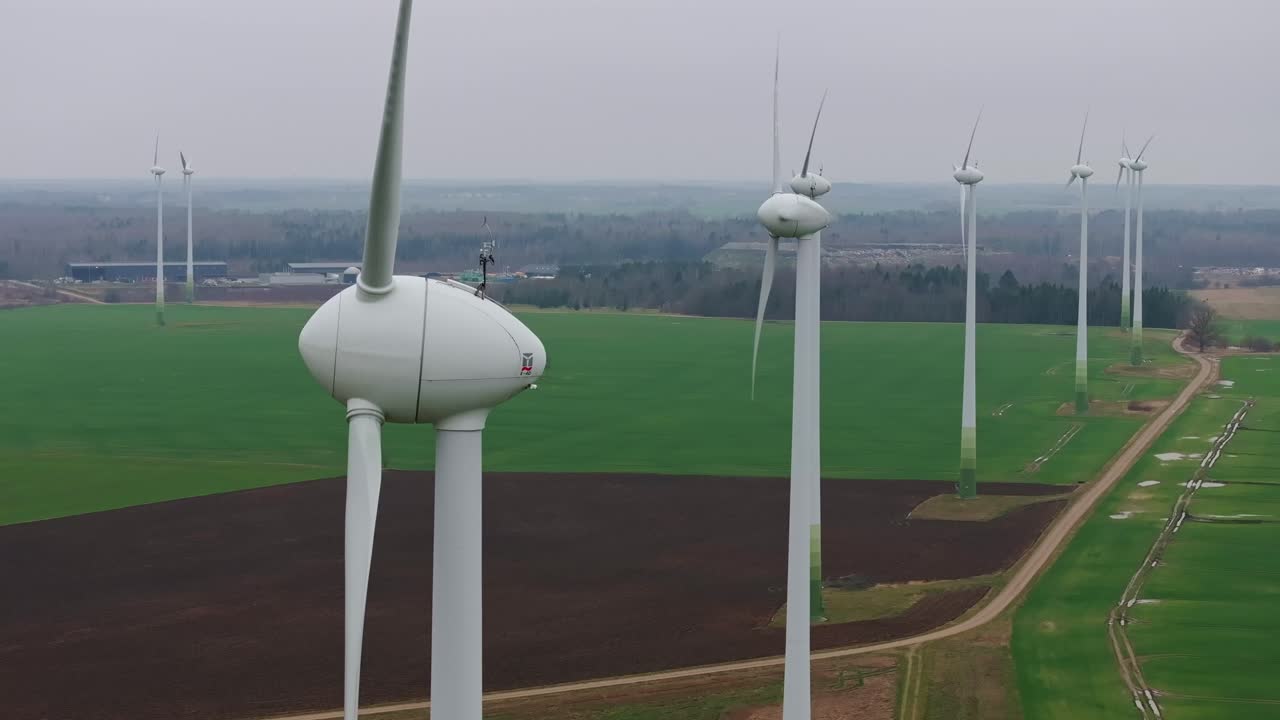 Slow-motion drone of wind turbines spinning gracefully in Grobiņa Wind Park