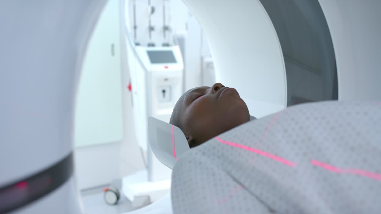 Lo scanner sta iniziando l'imaging e il tavolo sta spostando il paziente nel foro dello scanner, i laser si stanno allineando