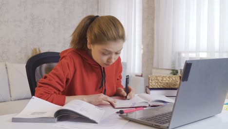 at home, the schoolgirl does homework, looks at the books and learns.