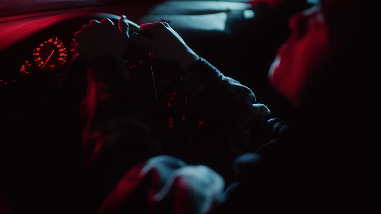 Persona che guida un'auto di notte con luci al neon