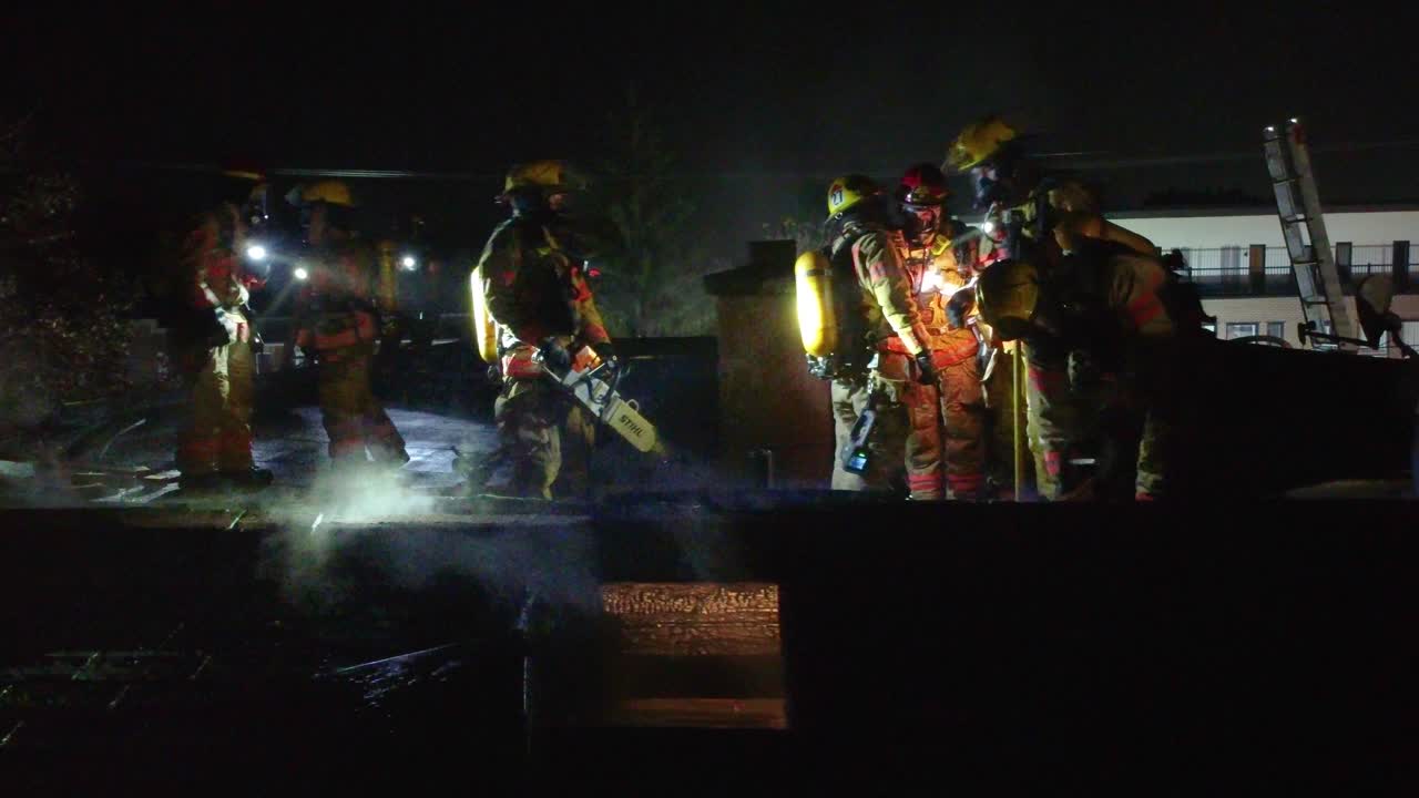 Nighttime rescue operation by firefighters on building terrace in Montreal, Canada.