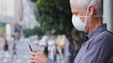 caucasian man out and about in the street wearing on a face mask against coronavirus