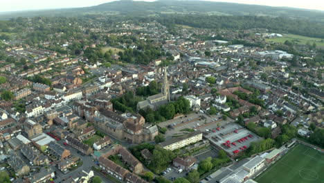 Smooth-drone-aerial-footage-of-classic-beautiful-English-Town-in-countryside,-with-old-church-in-frame