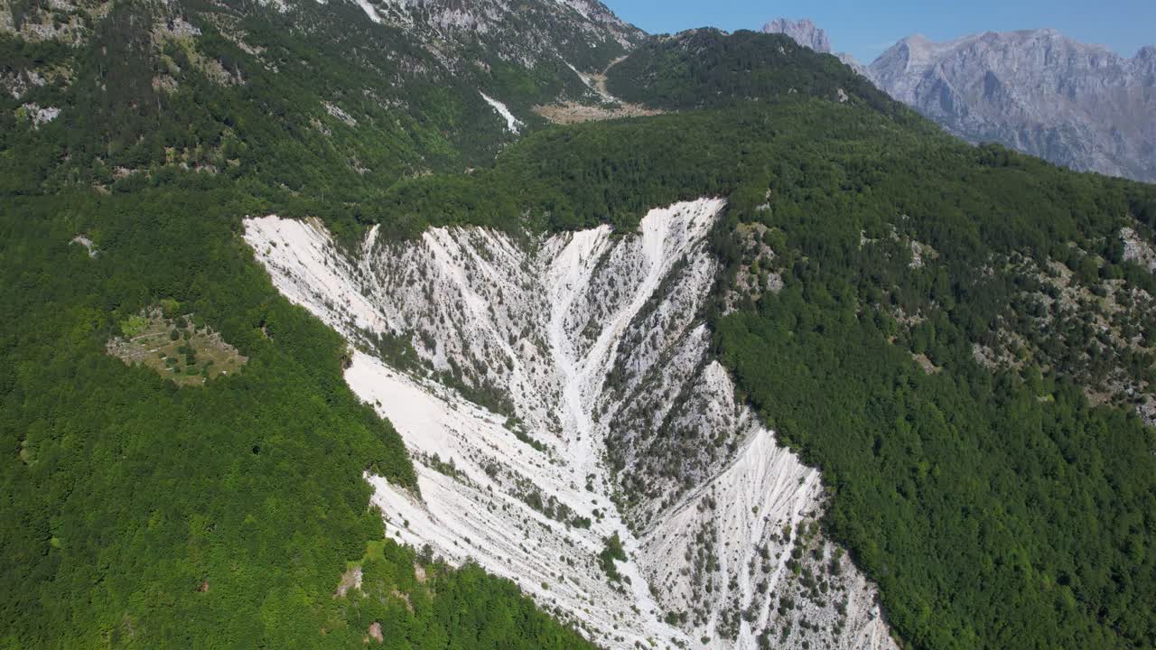 알바니아의 발보나 (valbona) 에 있는 산악 경치, 울창한 초록색 식물 속의  돌.